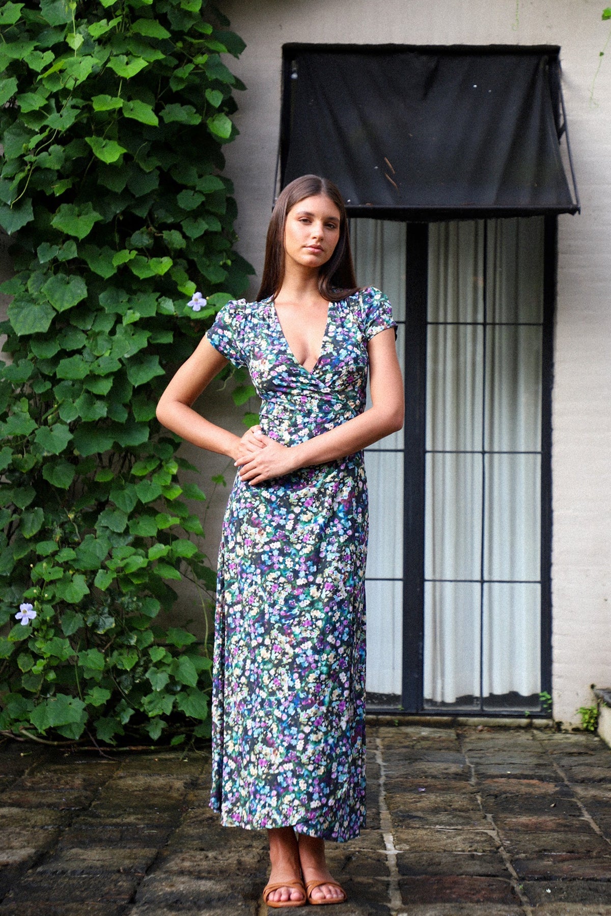 A person wearing the Alexa Maxi Wrap Dress in a floral pattern, standing outdoors.