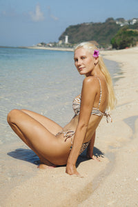 Woman wearing zebra print bikini standing on a beach