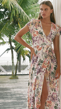 Woman wearing maxi floral wrap dress with her hands on her waist
