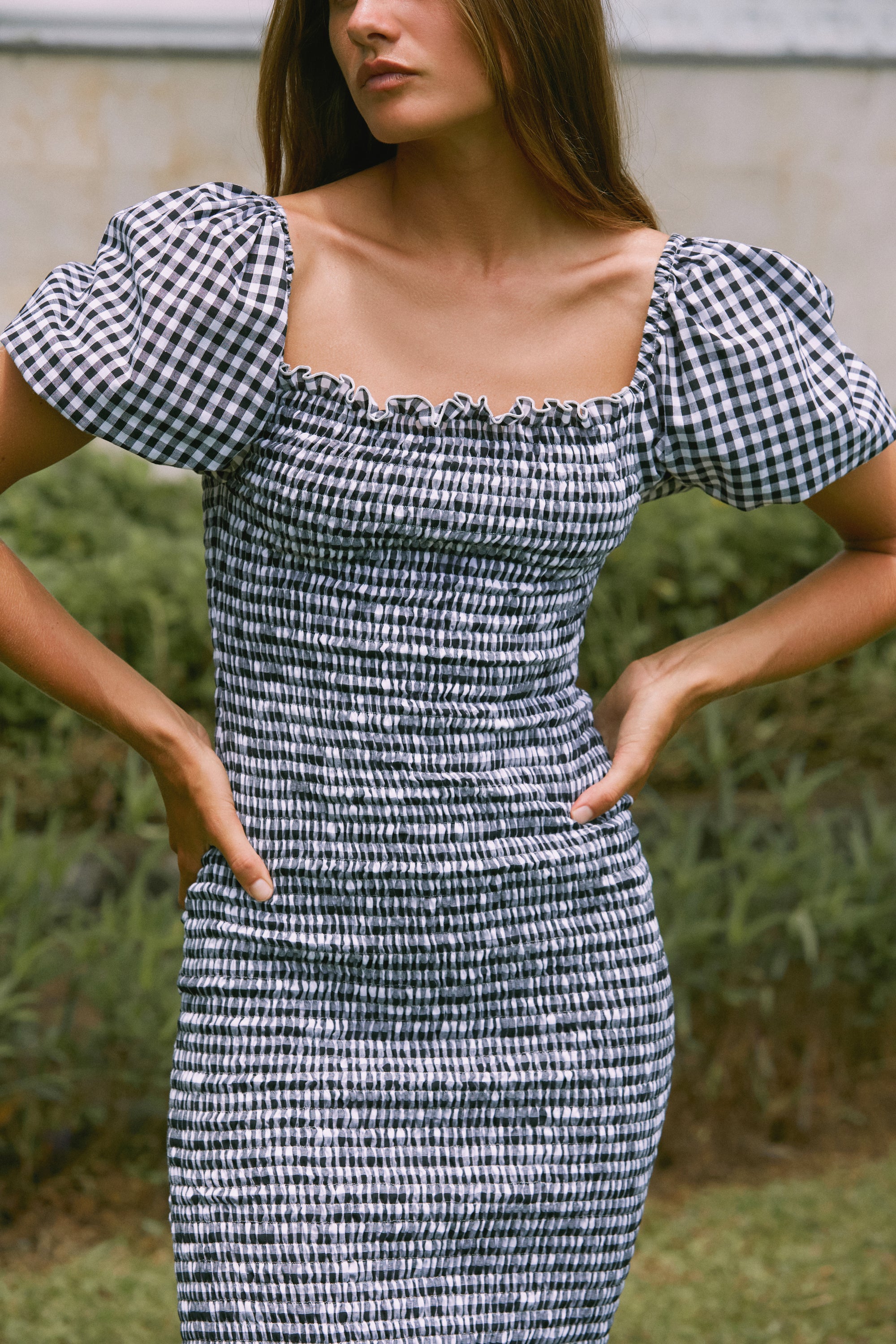 Close up view of a woman wearing Black gingham midi dress